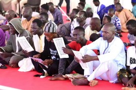 Pilgrims of the Mouride Brotherhood, a Sufi order, read khassayites, written by their spiritual guide Serigne Touba, under a tent near the Great Mosque of Touba, on October 27, 2018 ahead of the religious festival of the Magal commemorating the exile of its founder, the great marabout Sheikh Amadou Baba. (AFP/Seyllou)